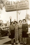 Women pose in front of 1930 Glendora Library sign